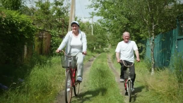 Aktivní životní styl, veselý starý pár babička a dědeček se společně baví na kole při rodinné jízdě na kole v přírodě — Stock video