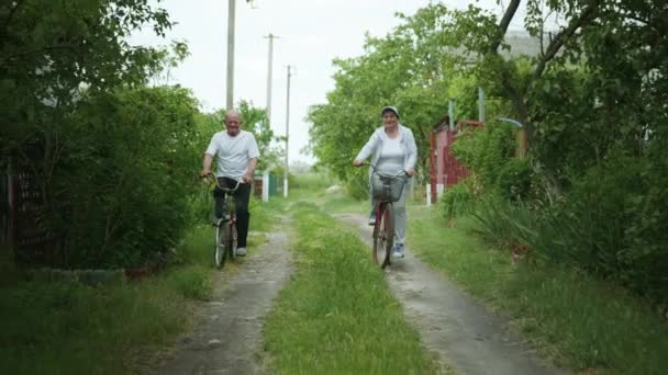Venkovní aktivity, veselé starší páry baví cyklistika po venkově — Stock video