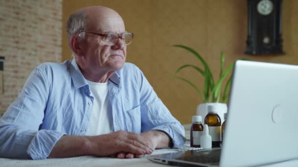 Moderne geneeskunde, oudere man communiceert online met arts via videocommunicatie via laptop — Stockvideo