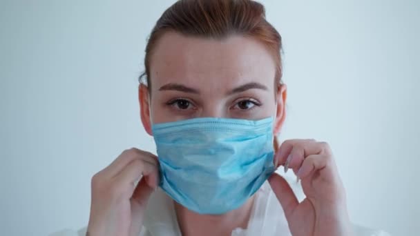 Médico feminino triste usa um terno protetor e máscara, enfermeira está pronta para receber pacientes durante a epidemia e coronavírus — Vídeo de Stock