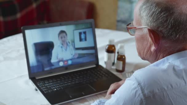 Patiëntenzorg, bejaarde oude man raadpleegt zijn arts via videocommunicatie met behulp van moderne technologieën — Stockvideo