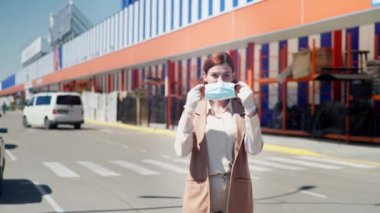 Coronavirus ölçümleri, tıbbi maskeli kadın alıcılar ve virüs ve hastalıklara karşı korunmak için eldivenler girişte el duruşu gösteriyor.