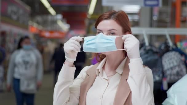 Handla på coronavirus, kvinna köpare bär mask och handskar när du handlar i karantän på grund av ett coronavirus i en butik mitt i — Stockvideo