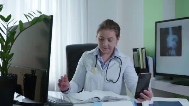 Médecine moderne, femme employée de l'hôpital travaille en ligne avec les patients enregistre les symptômes de la maladie ou des rhumes counseling en ligne via vidéo — Video