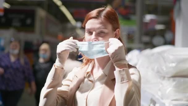 Pandemie a bezpečnostní opatření, portrét dospělé dívky v lékařských rukavicích, nasazující si masku na ochranu proti viru a infekci na veřejném místě v supermarketu — Stock video