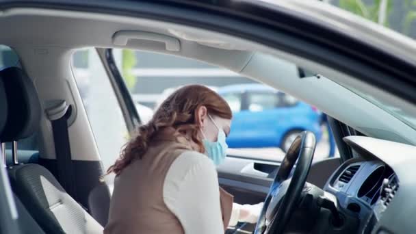 Soins de santé, jeune conductrice en masque médical et gants désinfecte les mains et le volant avec antiseptique — Video