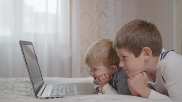 Mosolygós jóképű óvodás gyerekek férfi néz vicces film rajzfilmek laptop — Stock videók