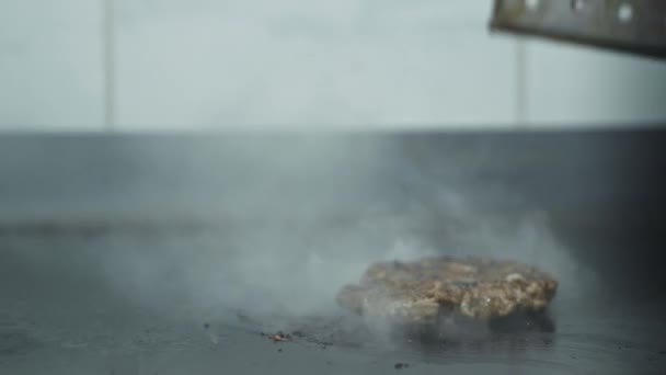 Процес приготування соковитого ніжного медальйону або котлети на грилі для бургеру, подрібнене м'ясо перекинуте шпателем для приготування їжі на кухні ресторану — стокове відео