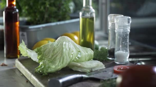 適切な栄養、新鮮なジューシーなレタスの葉はおいしい健康的な料理を準備するためにまな板に置かれます — ストック動画