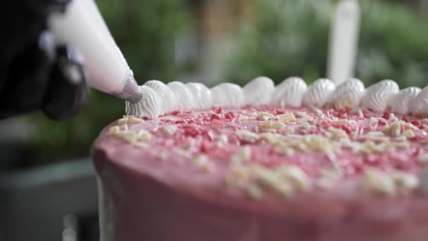 Cocina, una chef femenina decora un pastel de galletas dulces hechas a mano con una bolsa de pastelería y crema, primer plano — Vídeos de Stock