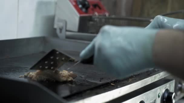 Koken vlees op grill, mannelijke kok handen in handschoenen verandert sappige plakjes vlees tijdens het bakken achtergrond van rook in de keuken van fast food — Stockvideo