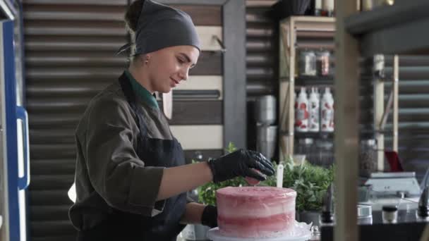 달콤 한 파티, 예쁜 여자 요리사 가 식당이나 카페에 있는 아름다운 크림 케이크에 달콤 한 크림을 뿌리는 모습 — 비디오