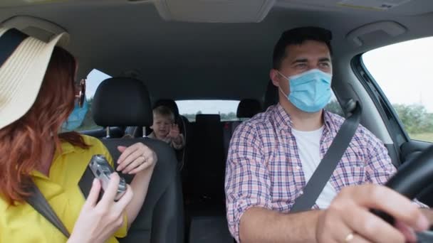 Περιπέτειες, ευτυχισμένο ζευγάρι με ιατρικές μάσκες απολαμβάνει οικογενειακό ταξίδι με τα παιδιά τους και παίρνει φωτογραφίες μνήμης με ρετρό κάμερα κατά τη διάρκεια ταξιδιού σπόρων με το αυτοκίνητο το καλοκαίρι — Αρχείο Βίντεο