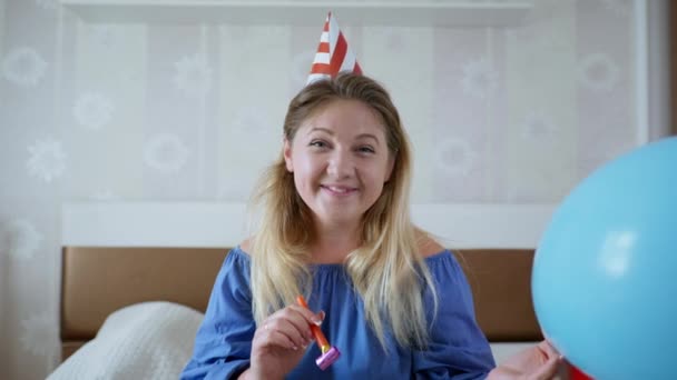 Соціальна відстань, чарівна усміхнена дівчина з трубкою і дзвоном розмовляє на веб-камеру на ноутбуці і святкує день народження онлайн — стокове відео