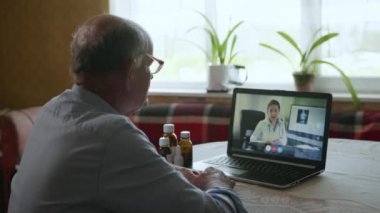 Modern tıp, yaşlı adam internetten doktora danışır, genç bayan doktor modern teknoloji kullanarak yaşlı hastalarla iletişim kurar.