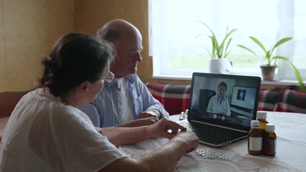 Семейные пожилые пары мужчина и женщина проконсультироваться с врачом в Интернете о болезни и симптомах во время телемедицинского видеозвонка с использованием современных технологий — стоковое видео