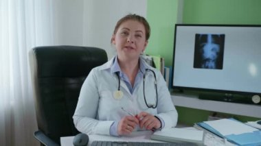 Uzak tıp, kadın doktor modern teknolojilerin yardımıyla çevrimiçi bir konsültasyon yürütüyor ve bir röntgen fotoğrafı kullanarak hastalığın nedenleri hakkında konuşuyor.