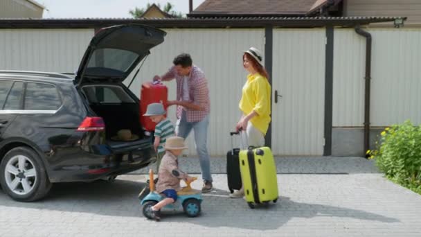 Vacaciones de verano, feliz familia amorosa con los niños que van de viaje en coche carga viaje maleta en el maletero para el viaje — Vídeos de Stock