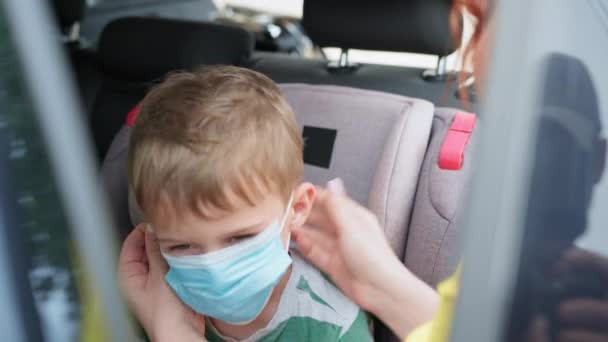 Quarantaine, parent féminin soignant ne met pas de masque médical pour l'enfant pour le voyage en voiture pendant la pandémie de coronavirus — Video