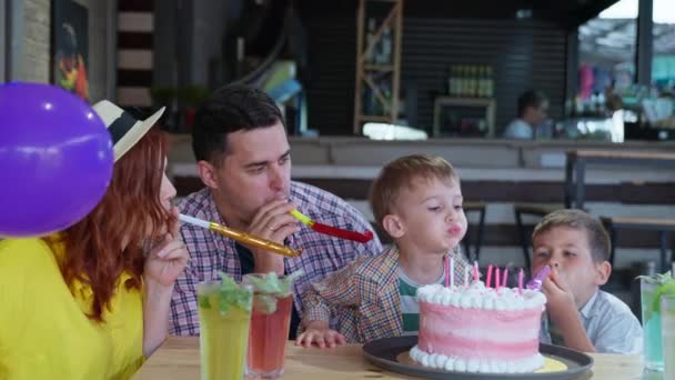 Festa festiva, pais carinhosos alegrar seus filhos feliz aniversário, juntamente com seus filhos amados, tubo de sopro e soprar velas no bolo doce — Vídeo de Stock