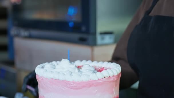제빵사는 제빵사가 손으로 주방에서 준비 한 케이크에 촛불을 놓고 제빵 사업을 하고 있는 방문객들을 축하 한다 — 비디오