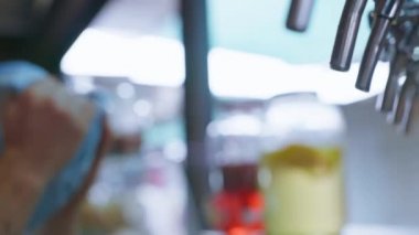 Yakın plan, profesyonel barmen fıçıdan bira fıçısını bardağa doldurur.