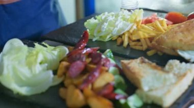 Fast food, lezzetli kızarmış patatesler, siyah tabakta salata sosu.