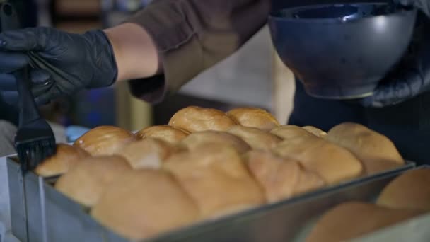ペストリー、手袋とパン屋は、シリコーンペストリーブラシ、クローズアップを使用してくちばしで新鮮な小麦粉の新鮮な熱い、香り高いパンを笑顔 — ストック動画
