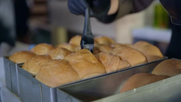 Bakkerij, chef-kok, condit vrouw in handschoenen smeert hete geurige broodjes uit de oven met siliconen gebak borstel — Stockvideo