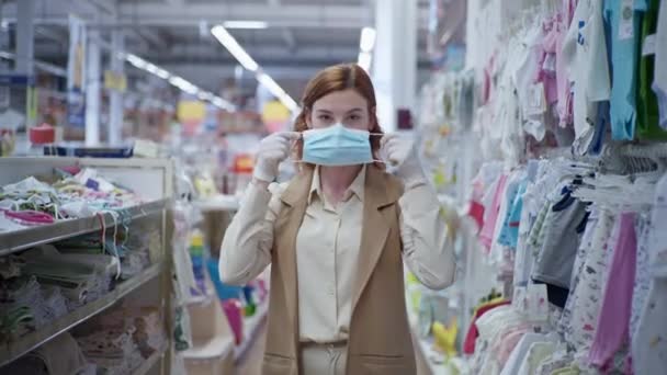 Handel med karantän, ung kvinna kund i medicinska handskar, sätter på ansikte mask i snabbköpet för att skydda sig mot virus och infektion under karantän pandemi — Stockvideo