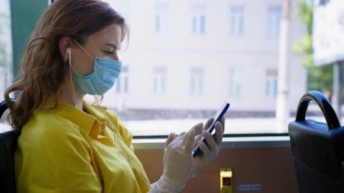 Kadın yolcu kamusal alanda kurallara uyar ve virüs ve enfeksiyondan korunmak için tıbbi maske takar ve karantina kaldırıldıktan sonra şehir otobüsünde işe giderken