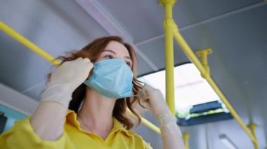 Kadınlar halka açık yerlerde güvenlik kurallarına uyuyorlar. Sağlık maskesi ve eldiven takarak otobüslere biniyorlar. Virüsten korunmak için.
