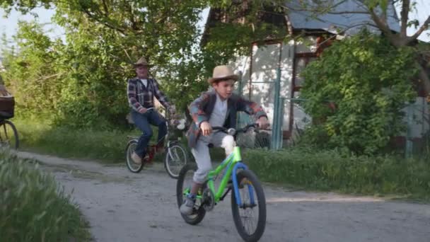Прелестные бабушка и внук наслаждаются выходными вместе и ведут активный образ жизни на велосипеде сельской дороге — стоковое видео