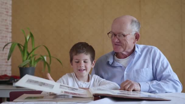 Moments heureux, petit garçon heureux avec son grand-père joyeux a des souvenirs de famille, regarder l'album photo — Video