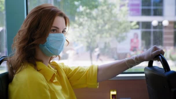 Femme observe les règles de sécurité dans les lieux publics en bus portant un masque médical et des gants pour se protéger contre le virus et l'infection enlève son respirateur tout en voyageant dans les transports publics après — Video