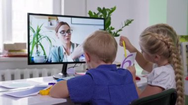 Salgın sırasında uzaklardan öğrenme, Down sendromlu küçük bir çocuk ve evinde bilgisayar başında oturan kadın öğretmeniyle matematik okuyan bir kız.