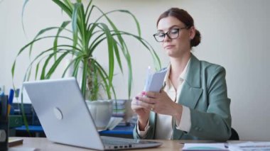 Çevrimiçi çalışma, kartlarla konuşan öğretmen bilgisayar kamerasıyla okulda masada oturuyor.