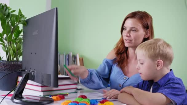 Aulas particulares, aluno com síndrome de down fazendo lição de casa da escola com professor usando computador — Vídeo de Stock