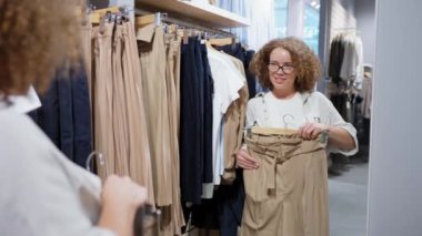 Bayan müşteri yeni kıyafetler seçiyor.