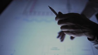 In an office, leaning over a large monitor instead of a desk, a man actively uses an interactive diagram on the screen. He then minimizes and removes the drawing file from the monitor screen. The