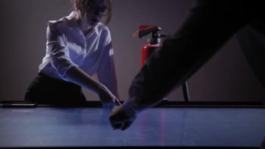 A woman and a man in an office in front of a large horizontal screen discuss work issues related to fire safety in buildings. The woman moves, enlarges, and positions an interactive diagram on the