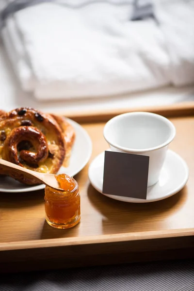 Tray with breakfast on a bed in hotel room