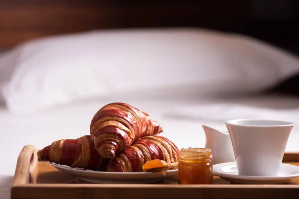 Tray with breakfast on a bed in hotel room