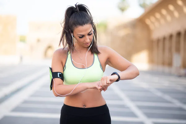 portrait of fit woman timing her heart rate with watch