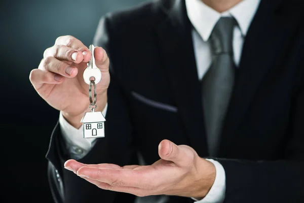 key chain with key in hand of a real estate agent