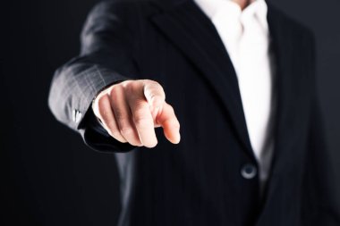 İş adamı işaret parmağı koyu arka plan üzerinde