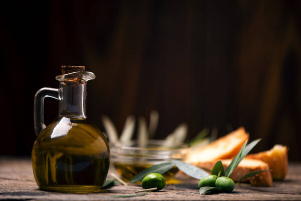 Olive oil with bread on a wooden table. Rustic  vintage composition