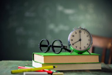 8: 00 okul kavramı ile geri. Yazı tahtası üzerinde arka plan ile çalar saat kitapları