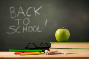 Apple theacher masasında kitap. Geri scool kavramı