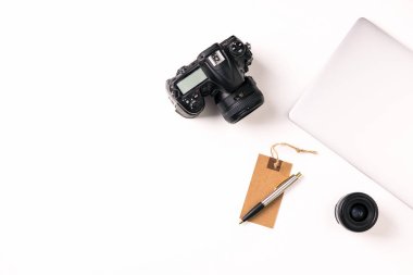 Dizüstü bilgisayar, kamera ve lens beyaz masa üzerinde istasyonu fotoğrafçı